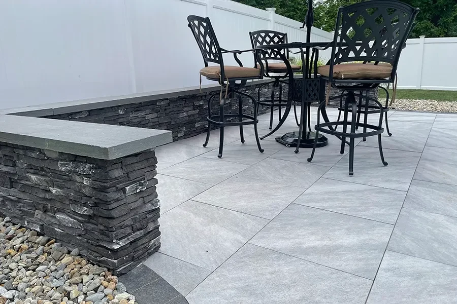 Porcelain patio with a stone seating wall