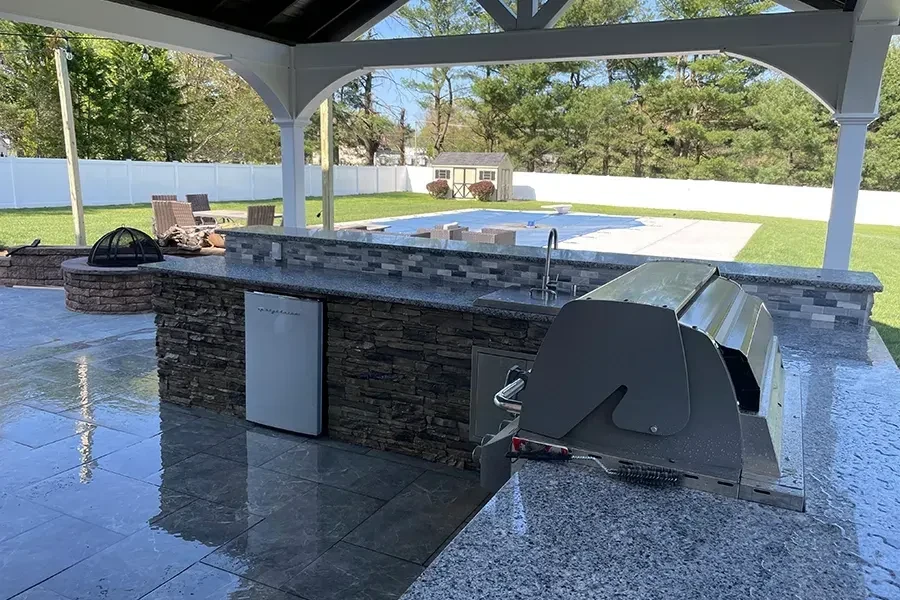 Stone outdoor cooking island under a pavilion